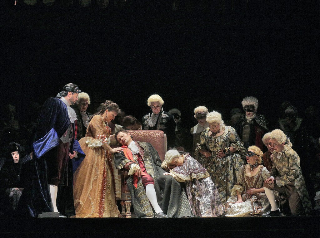 Gustav (Beczala) dying, Amelia (Stoyanova) and Company. Photo by Ken Howard. This scene with its choral crescendo is highly effective. DG
